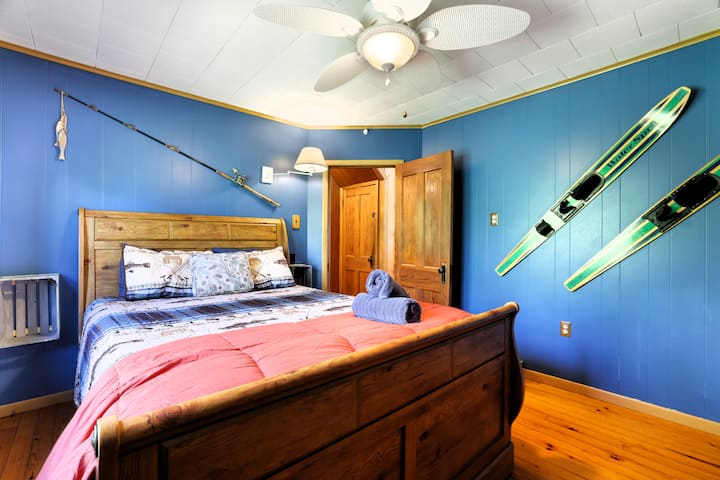 Acogedor dormitorio con temática lacustre, cama tamaño queen, ventilador y encanto rústico