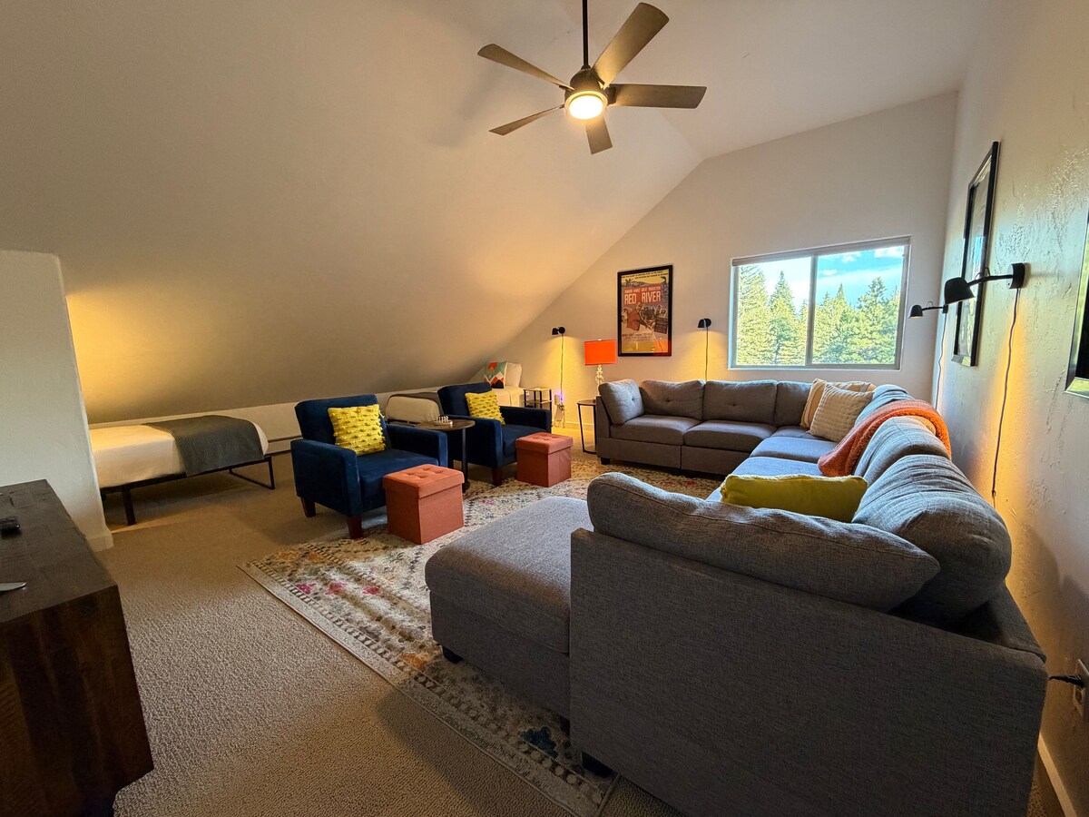 Le salon à l'étage est un espace spacieux avec un grand canapé et deux fauteuils confortables. La chambre est équipée d'une télévision intelligente. Deux lits simples nichés sous la pente de la pièce avec une literie luxueuse rehaussent l'espace.