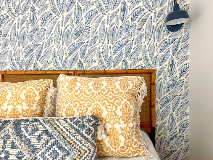 Beautifully decorated bedroom with Serena and Lily wallpaper, full closet, queen sized bed, and a cozy chair for reading. Every bedroom features blackout blinds and a sound machine for maximum sleeping comfort!