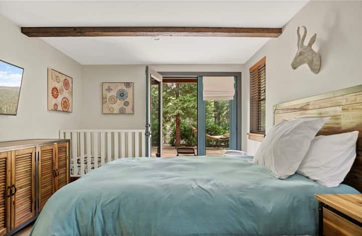 Este dormitorio se adapta cómodamente a una familia de 4 personas con una cama tamaño queen, una cuna y un futón (no se muestra).  La entrada privada al patio trasero y la ubicación al final del pasillo proporcionan un espacio agradable y tranquilo del ajetreo y bullicio del espacio principal.