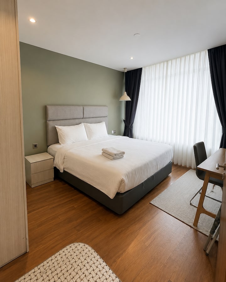 Chambre lumineuse et confortable avec de grandes fenêtres, lumière naturelle et une ambiance relaxante dans l'appartement Vortex KLCC.