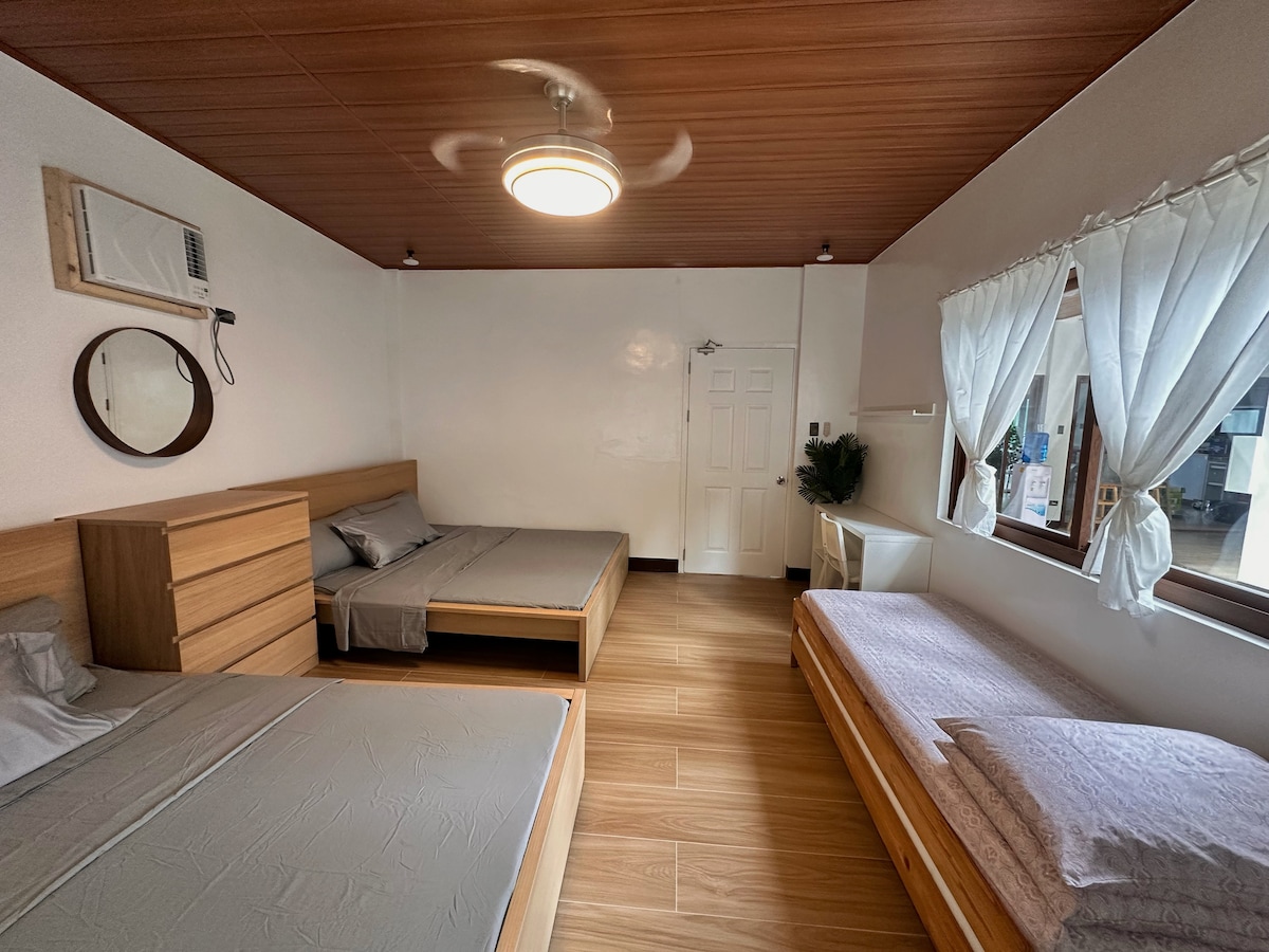 El dormitorio 2 tiene dos camas tamaño king y 2 camas individuales. Tiene capacidad para un máximo de 8 huéspedes. Hay una unidad de aire acondicionado y una mesa de estudio también.