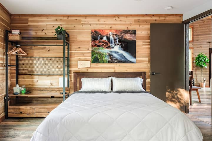 Bedroom #1 with storage, hangers, shelves, comfortable queen size bed, height-adjustable pillows, and USB A and C charging ports

