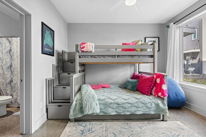 This bedroom sleeps 5 comfortably! Top bunk is twin bed, middle bunk is double bed, trundle bed hiding beneath is a twin bed and there’s a queen sized Courderoy Futon. All sheets, pillows and blankets are labeled and stored in bunk bed stair drawers.