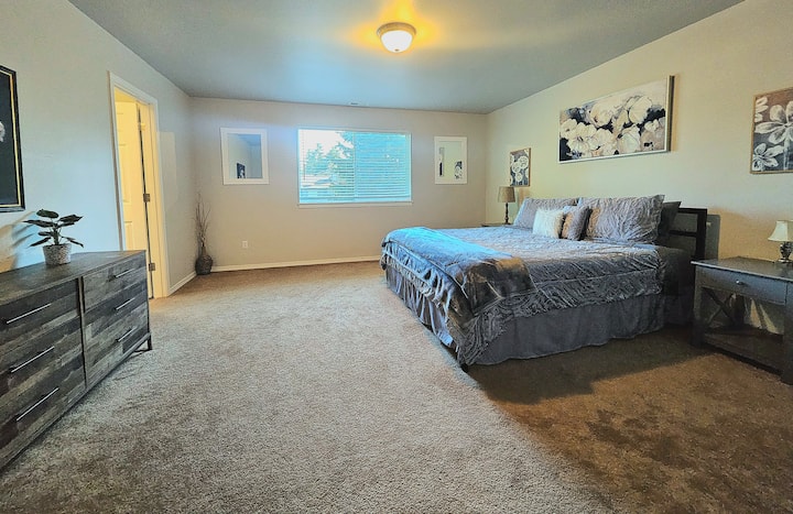 dormitorio grande con cama tamaño king y baño privado con vestidor contiguo