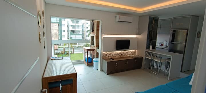 Sebule iliyo na kiyoyozi, runinga, meza, jiko la kuchomea nyama, kitanda cha sofa na jiko la wazi 