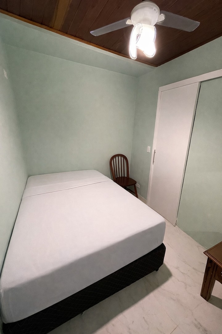 Udobna spavaća soba s bračnim krevetom, klima-uređajem i stropnim ventilatorom.