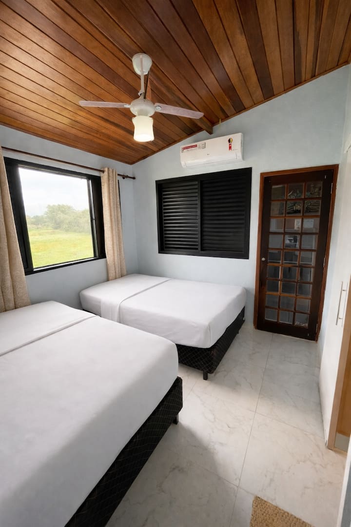 Udobna spavaća soba s dva udobna bračna kreveta, klima-uređajem, stropnim ventilatorom i dobrim prirodnim osvjetljenjem. 