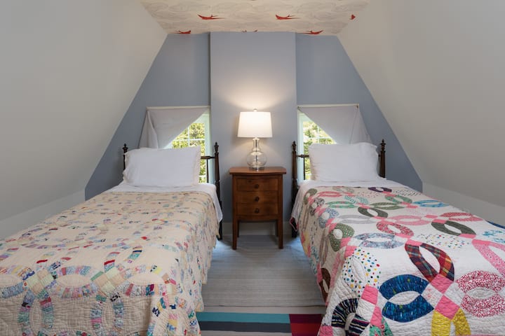 Two extra long twin beds on the third floor. Birds and clouds on the ceiling.