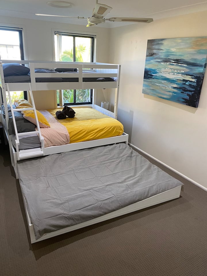 Haz que los niños duerman en esta habitación con una litera individual, una cama doble y una cama nido doble que se puede volver a meter. 