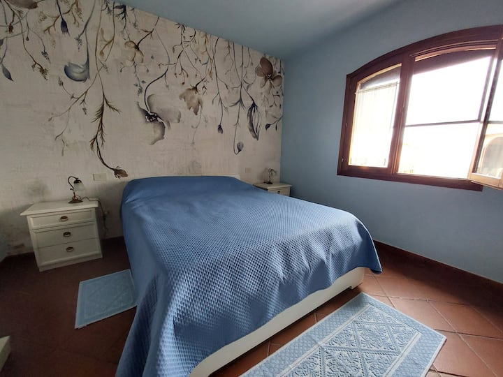 Large double bedroom with sea view window, air conditioning, safe and typical Sardinian furnishings