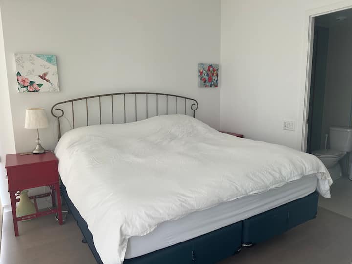 غرفة نوم رئيسية بسرير كبير وإطلالة واسعة على غرب المدينة. حمام داخلي بدش.