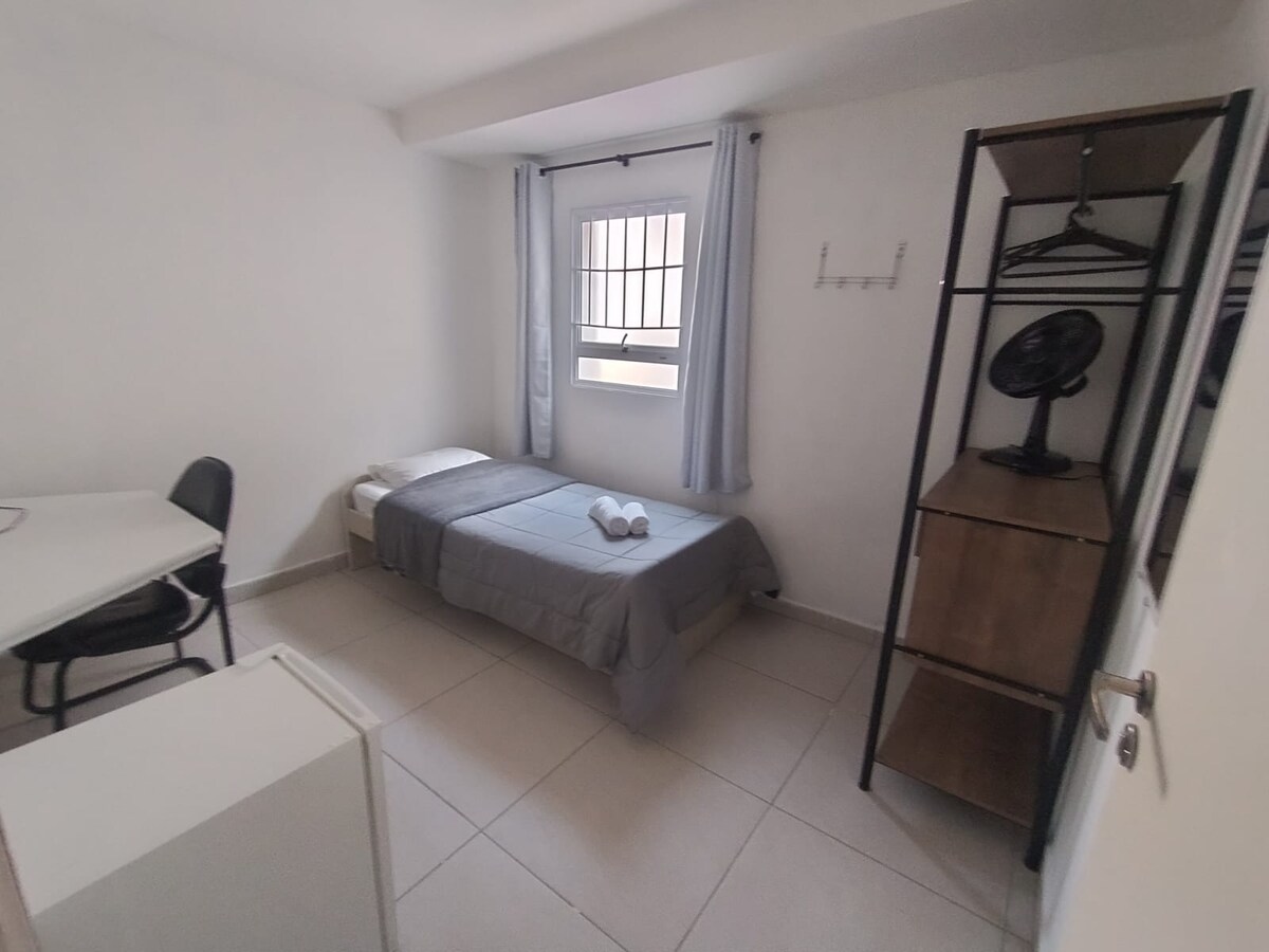 კომფორტული საძინებელი გარე ფანჯრით, ერთადგილიანი საწოლით (bicama), კარადით, სადაც არის საკიდები, საკაბინეტო/სამუშაო მაგიდითა და სკამით, ვენტილატორითა და მინი‑ბარით, რომელიც კარგად არის მოწყობილი და სრულყოფილია თქვენი კომფორტისთვის.