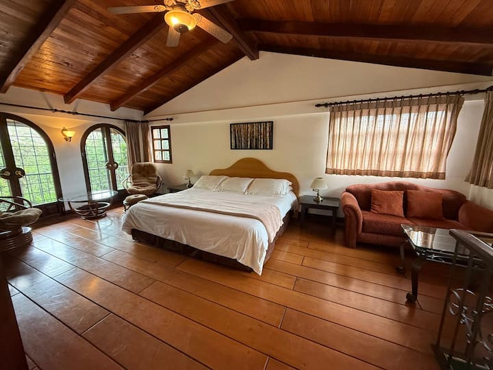 Главна спалня с подове от твърда дървесина с уютен кът за четене.