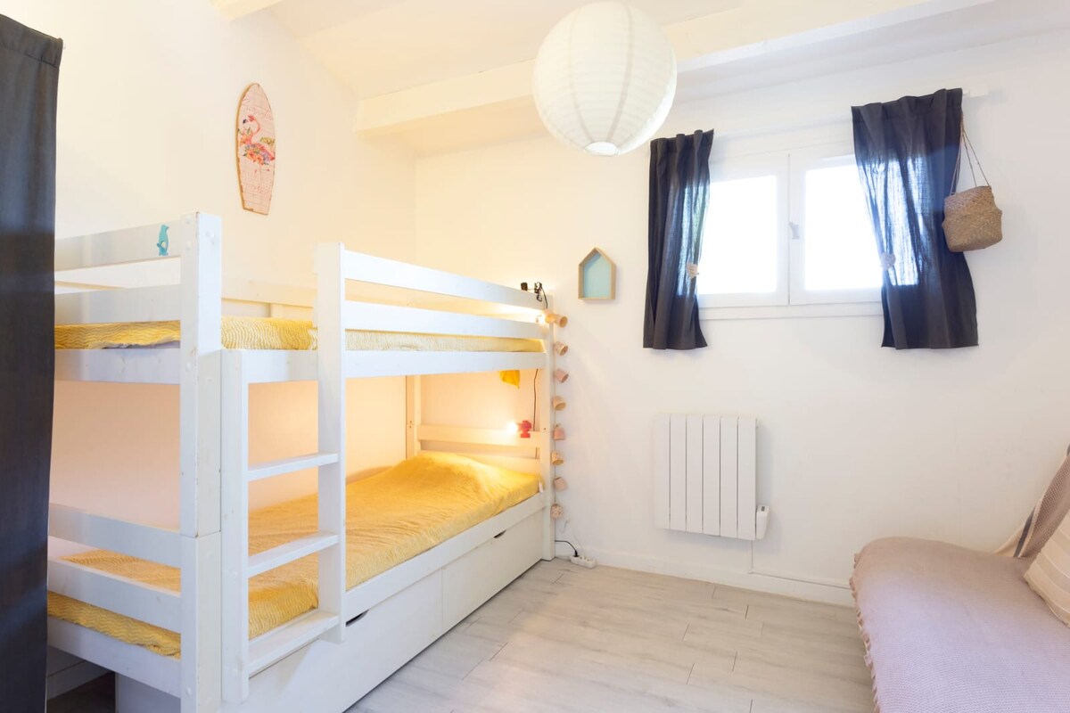 ห้องนอนชั้นบนมีเตียงสองชั้นและโซฟาเบดทางด้านขวาของรูป 