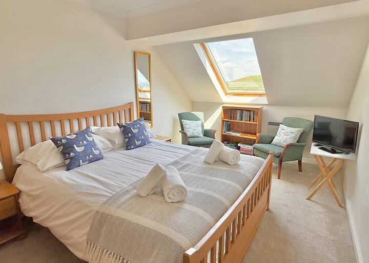 ห้องนอนใหญ่กว้างขวางมีเตียงขนาดคิงไซส์และวิวที่น่าทึ่งเหนืออ่าวและอบอุ่นและสะดวกสบาย มีหนังสือและทีวีมากมายเช่นกัน 