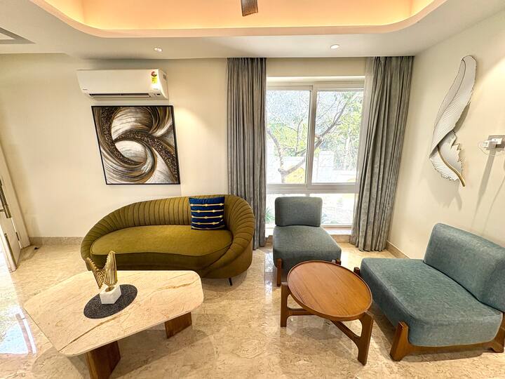 Where luxury meets space-an expansive 4BHK villa living room with double-height ceilings and plush c