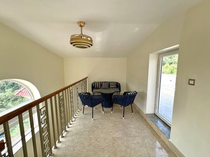 A cosy passage seating nook designed for relaxed moments within a luxury 4BHK villa.