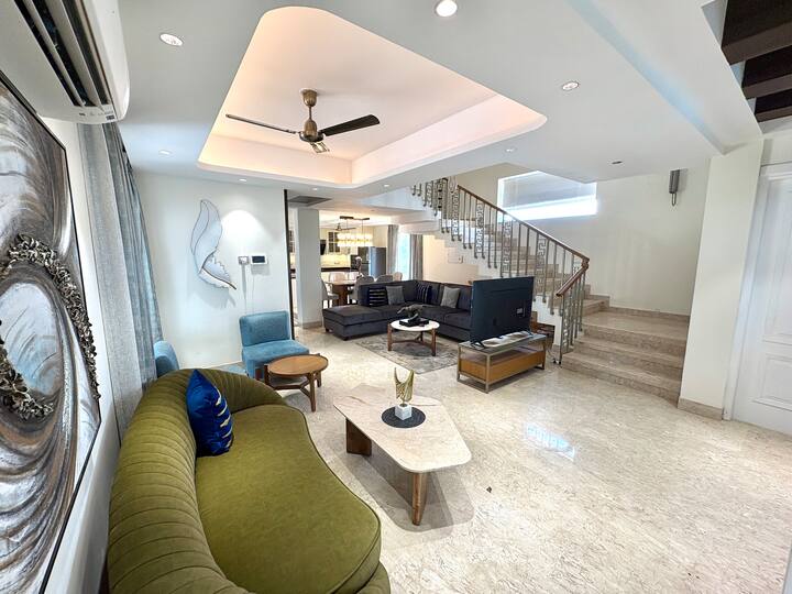Grand double-height luxury living room in a 4BHK villa, crafted for comfort, elegance, and premium l