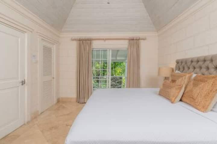 With stunning, high ceilings this en suite bedroom has ample clothes storage, ceiling fan and air conditioning.