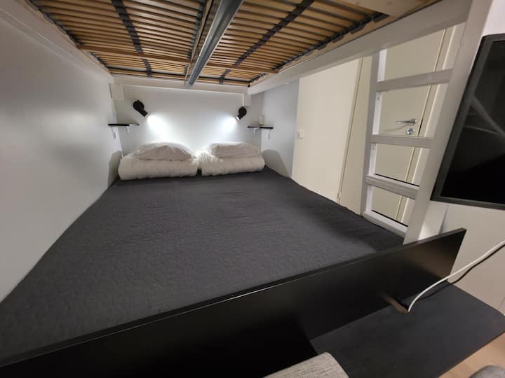 מיטת פוך 160 ס"מ. אורות חכמים מתכווננים גם במיטה (בהירות, גוון וצבע). גובה החדר הוא 270 ס"מ, כך שיש שפע של מקום בגובה המיטות. המיטה מתאימה גם היטב. הטלוויזיה החכמה גם ניתנת לצפייה במיטה.