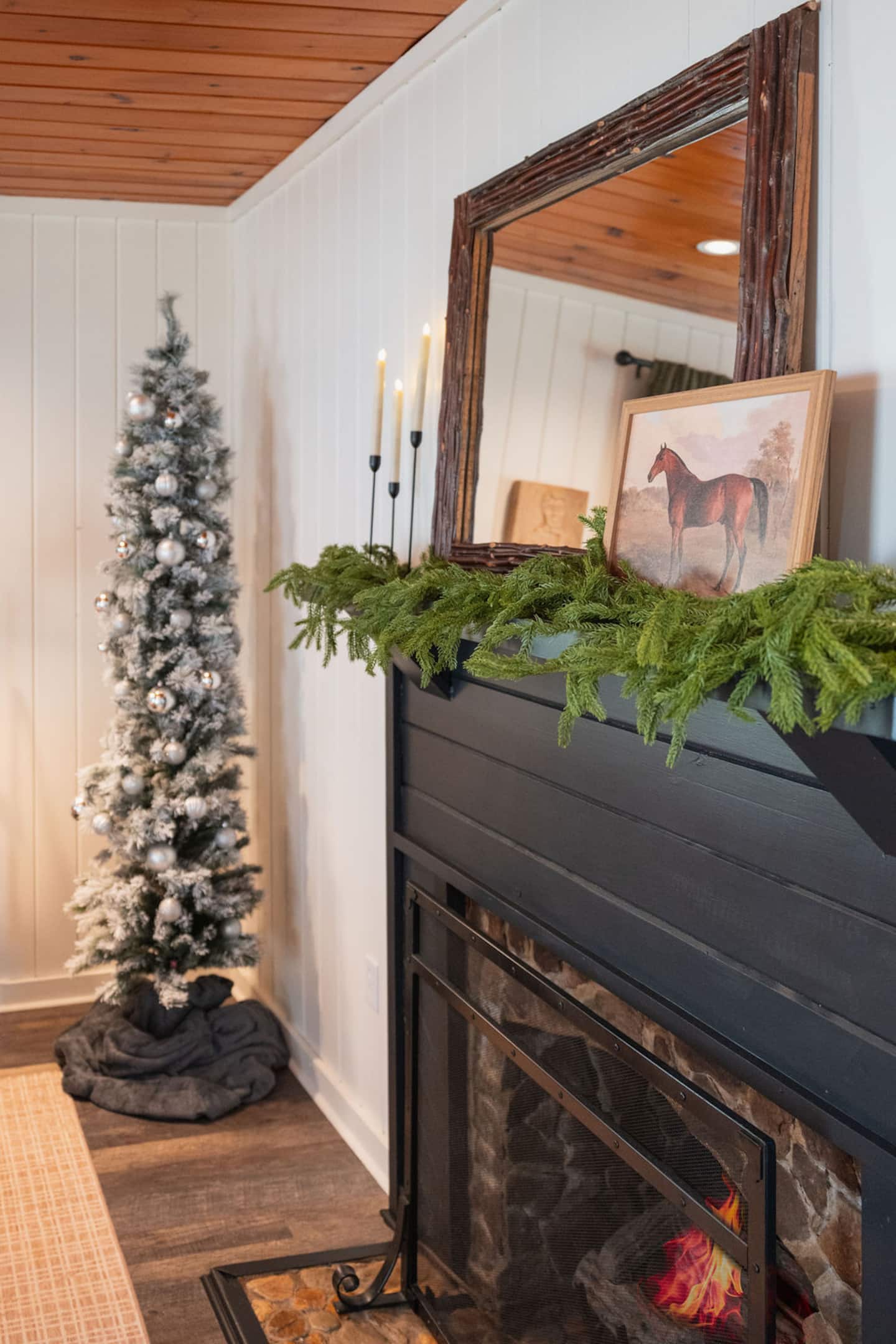 Switch on the flameless candles along the mantel, watch the fire glow beneath the garland, and let the whole cabin settle