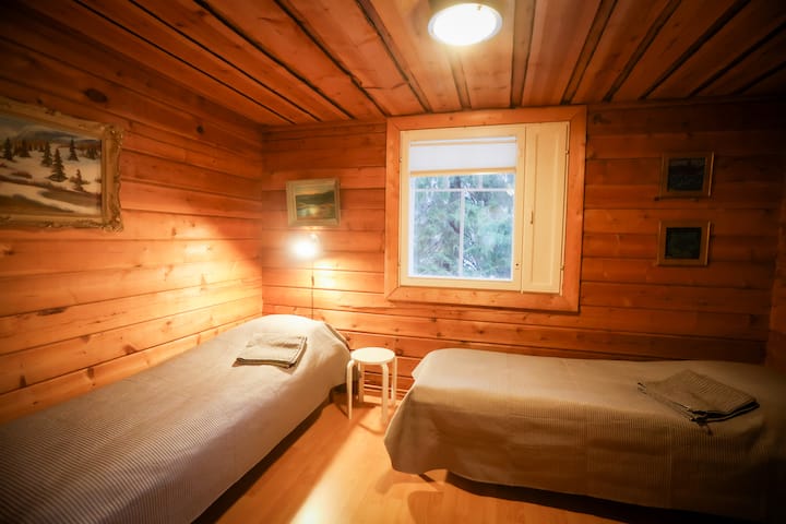 Downstairs bedroom. Two single beds, a clothes rack.