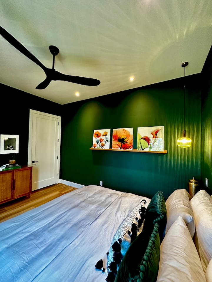 The embracing feel of the green bedroom features luxurious linens and fine art.
