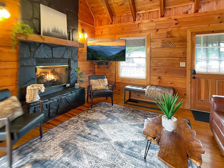 Downstairs living space with cozy gas fireplace, smart TV, and a queen sleeper sofa