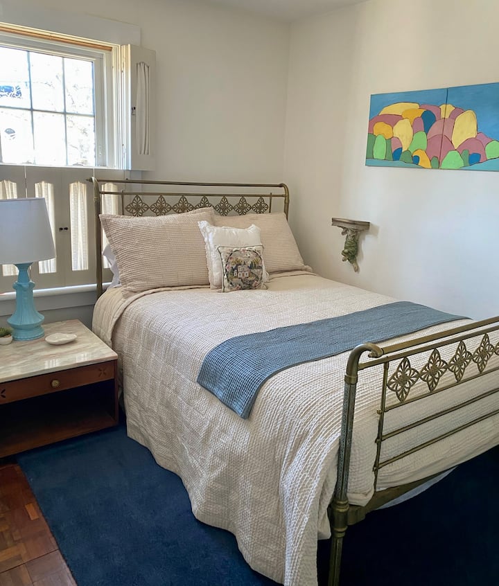 El dormitorio de arriba tiene una cama completa en un antiguo marco de latón inglés. Incluye un armario doble, portaequipajes, espejo de cuerpo entero, estantes abiertos y, por supuesto, una lámpara de lectura junto a la cama.