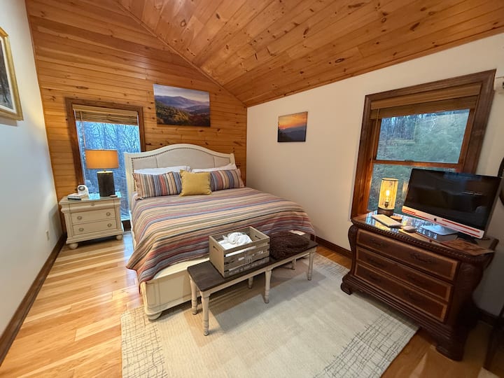 Upstairs king bedroom with lovely views from the large windows.  The house has new Hickory wood floors throughout the entire house.  While some areas having accent rugs,  there is no carpet in the house.  