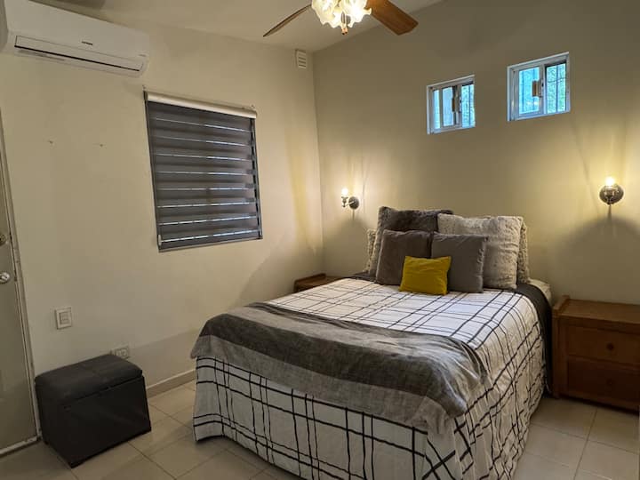 Room with queen size bed, mini-split A/C, ceiling fan, closet, dressing table, full-length mirror, stool