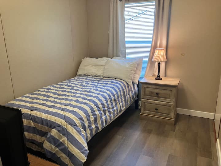 Ორადგილიანი საწოლი ლამაზი სქელი მატრასით, რომელსაც აქვს ტუმბო და სკამი, 32 სმარტ-ტელევიზორი და უშუქო ფარდები.