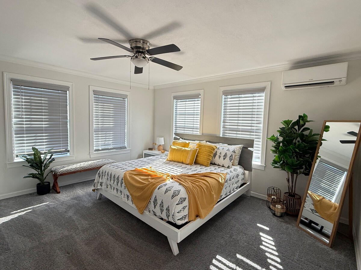 Chumba kikuu cha kulala chenye kitanda kikubwa cha kifahari na televisheni janja ya inchi 43