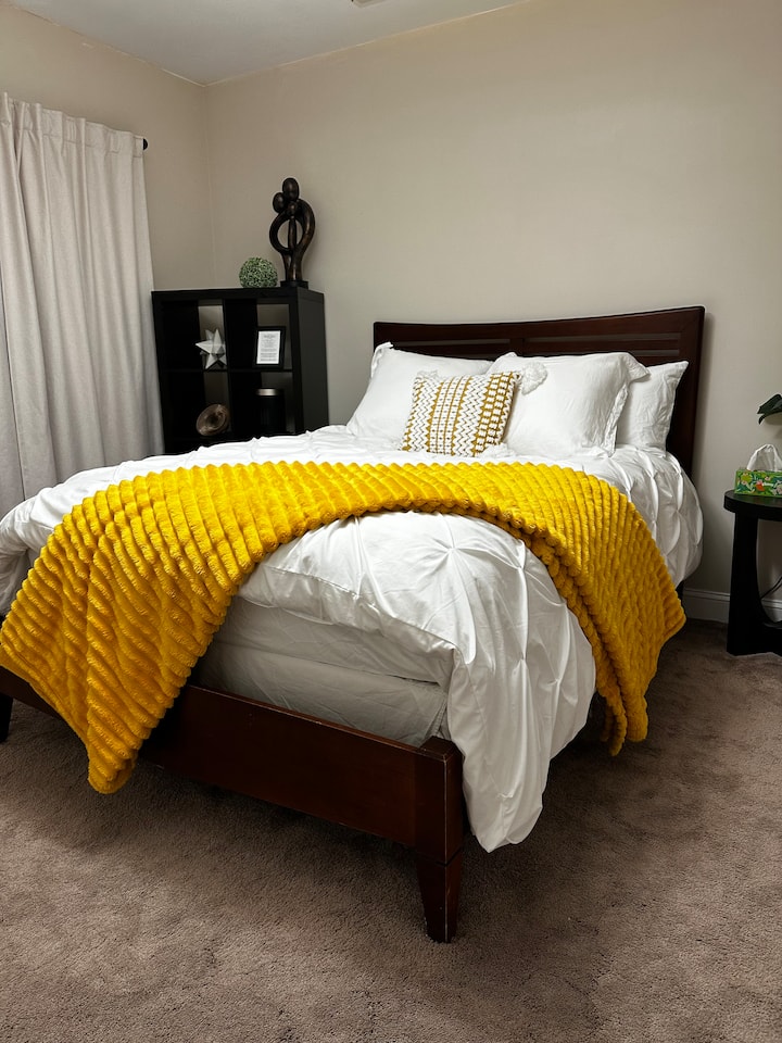 Comfortable queen bed with feather duvet, feather bed topper, Egyptian cotton linens, extra blankets.  Room has a space heater, side table, natural lighting, open shelf storage, and fire escape. 