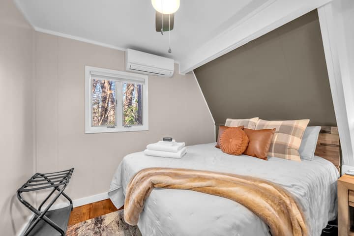 Queen sized bed room with luggage rack, clothes rack, mini split type HVAC, and smart tv. Bed is equipped with 100% Egyptian cotton sheets. Enjoy the roll out windows for that cool mountain breeze!