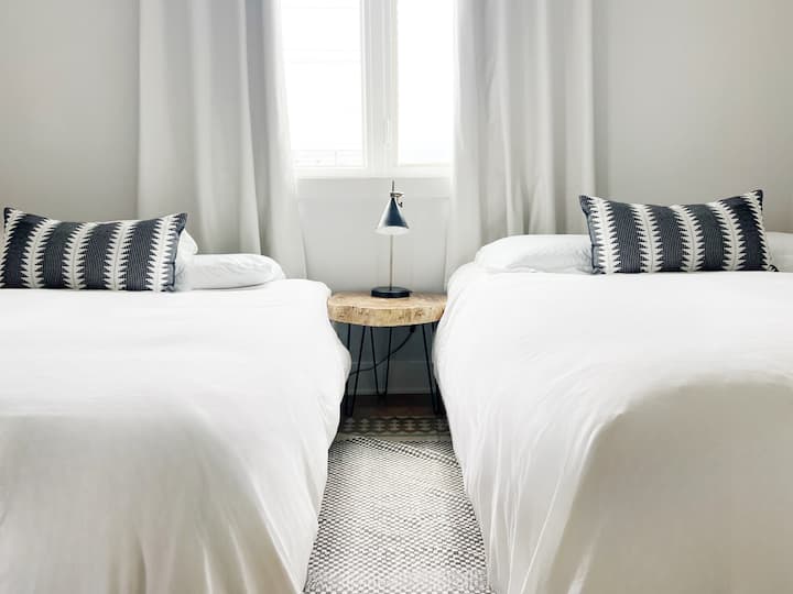 This room has two queen beds to accommodate larger groups! Also not pictured is a large full length mirror. 