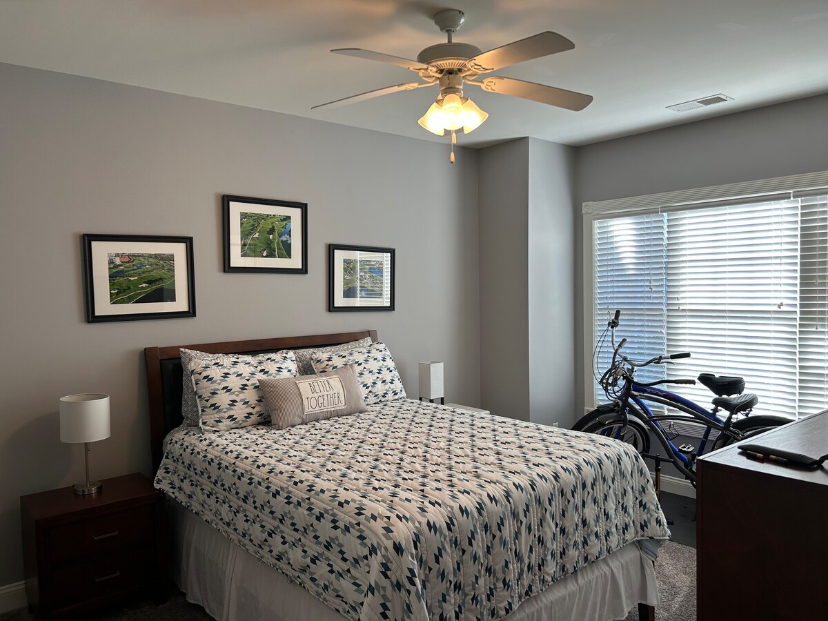 Pumzika katika chumba kikuu cha kulala chenye mwonekano wa maji, televisheni na kitanda kizuri.