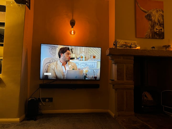 Cosy living room interior with warm lighting, wood burner glowing