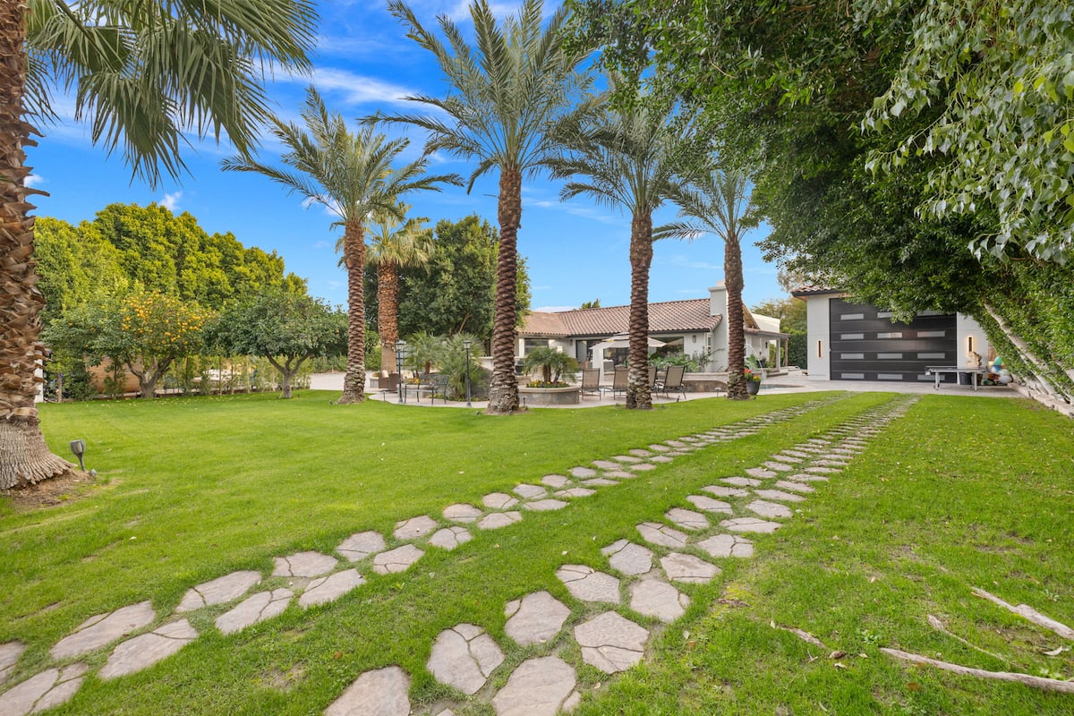 Lawn and grounds with stepping stones and mature palms