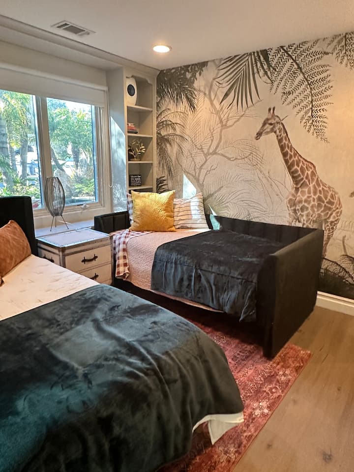 2 camas individuales con vistas al jardín privado. La habitación tiene persianas oscuras.