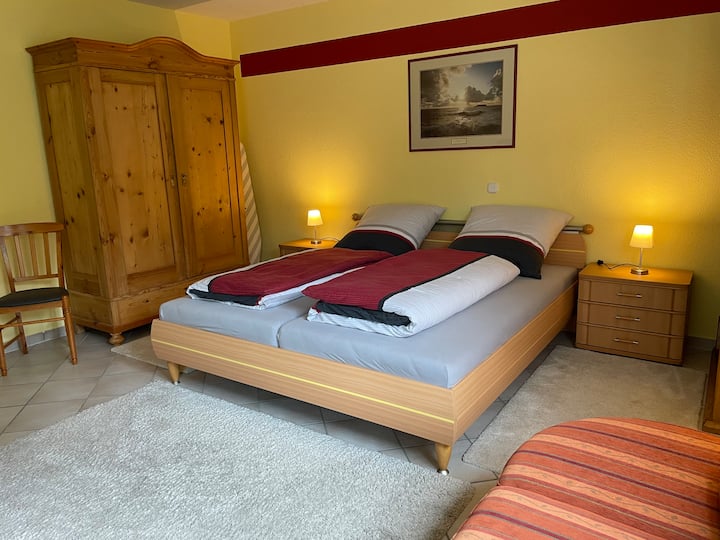 Hay un dormitorio grande y acogedor con una cama de 2 x 2 m y un armario.
