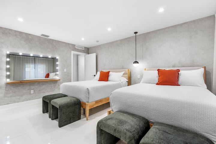 Elegantna dvosobna garsonijera s modernim visećim svjetiljkama, glamuroznim ogledalom i zidovima u umirujućim bojama.