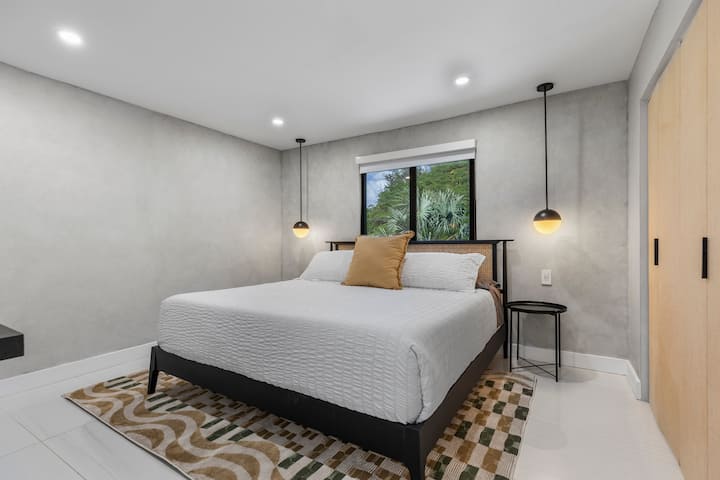 Opustite se u ovoj elegantnoj spavaćoj sobi s udobnim bračnim krevetom, toplim osvjetljenjem i pogledom na bujno zelenilo.