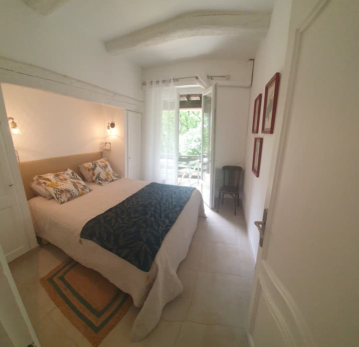 ห้องนอนใหม่ที่มีเตียงหนา มองเห็นระเบียงและโต๊ะเล็กๆ 