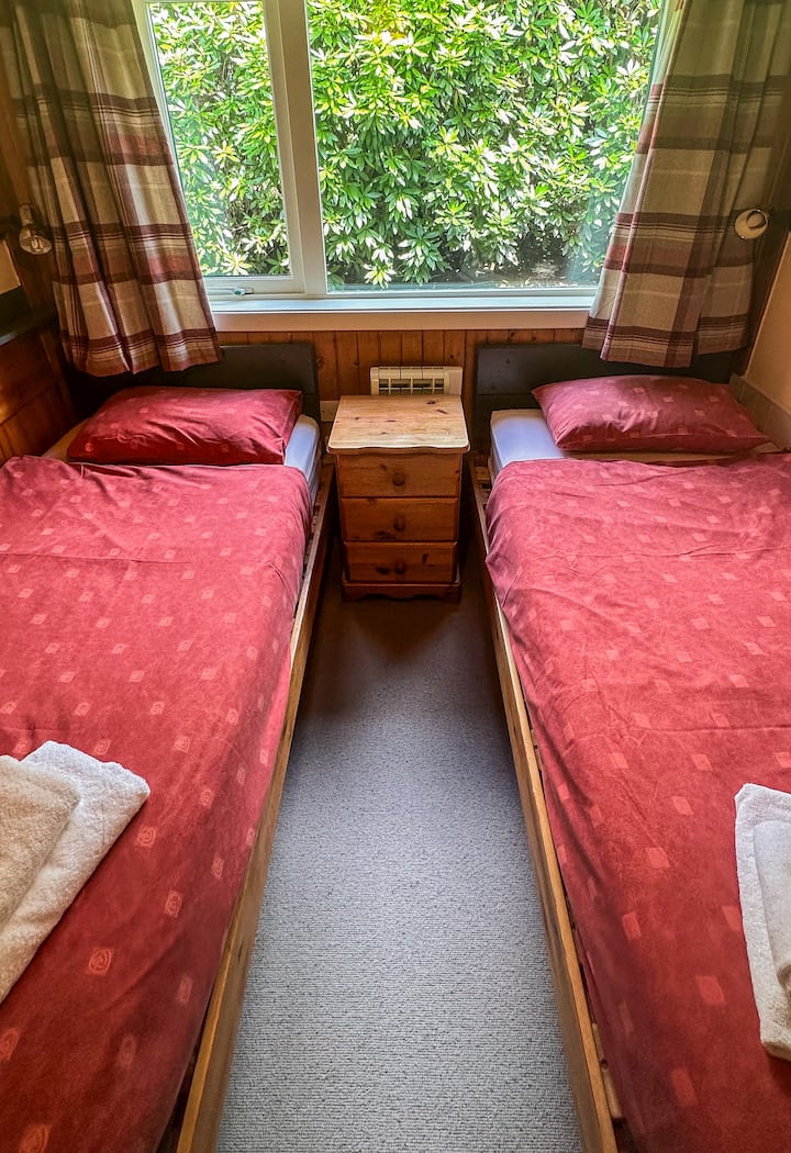 Ხის სახლს აქვს ორადგილიანი საძინებელი, 2 ერთადგილიანი საწოლით. Ეს საძინებელი უკანა მხარესაა და ხედები არ აქვს.