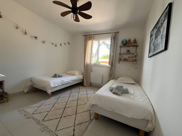 ห้องพักชั้นล่างพร้อมพัดลมเพดานและม่าน - เตียงขนาด 90 นิ้ว 2 เตียงที่สามารถรวมกันเป็นเตียงขนาด 180 นิ้วได้ 
เครื่องปรับอากาศ 