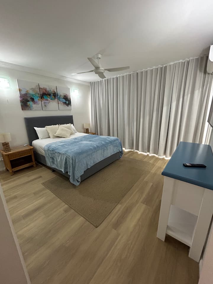 Основна спалня с двойно легло, пълни огледални гардероби, телевизор на стената с интернет връзка за стрийминг услуги и стандартно телевизори, с достъп до частна долна палуба, сплит климатик и вентилатор на тавана