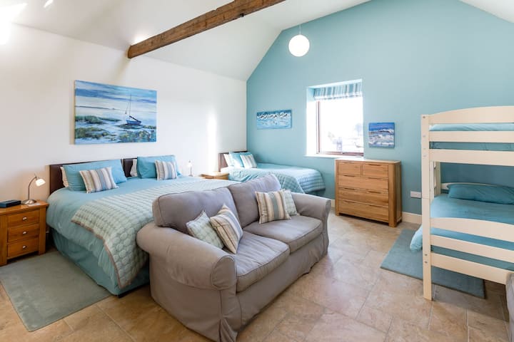 Kittiwake est une chambre familiale spacieuse pouvant accueillir confortablement deux adultes et trois enfants, avec un très grand lit, un lit simple et des lits superposés. Notez que cette chambre est accessible par deux marches.