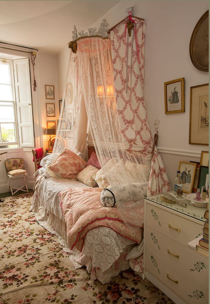 La chambre grise. Le lit à baldaquin de style français agit comme une « chaise » remplie de coussins pour se détendre en journée.